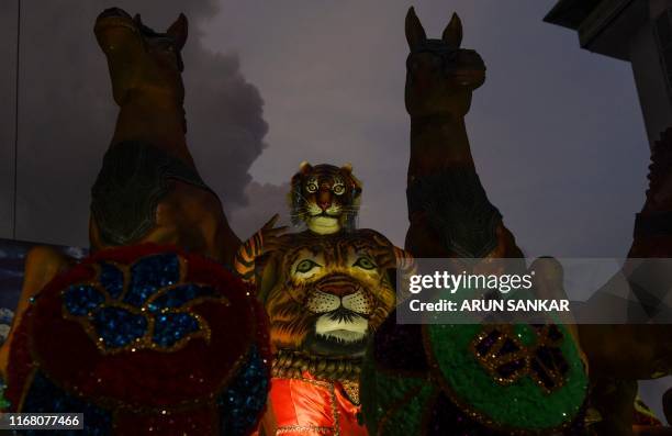 Performers adorning paintings of tigers on their bodies take part in the 'Pulikali' in Thrissur on September 14, 2019.