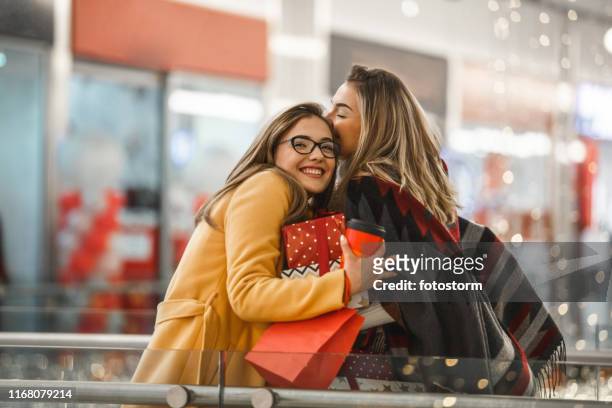 sisters sharing christmas presents - friends embracing stock pictures, royalty-free photos & images