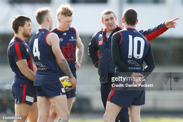 Demons head coach Simon Goodwin speaks to his players during a Melbourne Demons AFL training session at Gosch's Paddock on August 15, 2019 in...