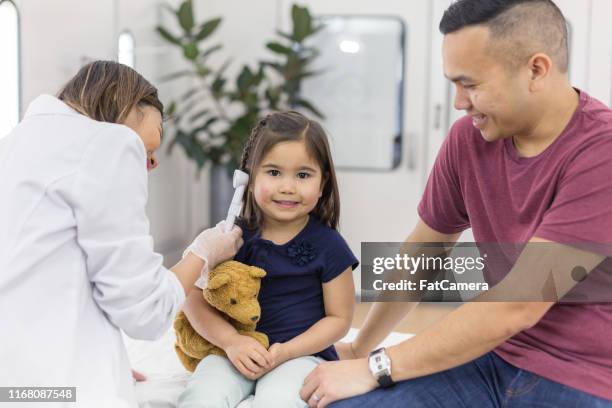 young ethnic girl at the doctor's office getting a checkup - ear care stock pictures, royalty-free photos & images