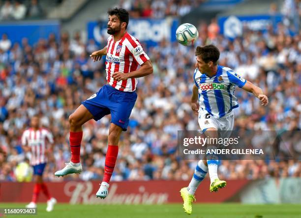 Atletico Madrid's Spanish forward Diego Costa vies with Real Sociedad's Spanish defender Aritz Elustondo during the Spanish league football match...