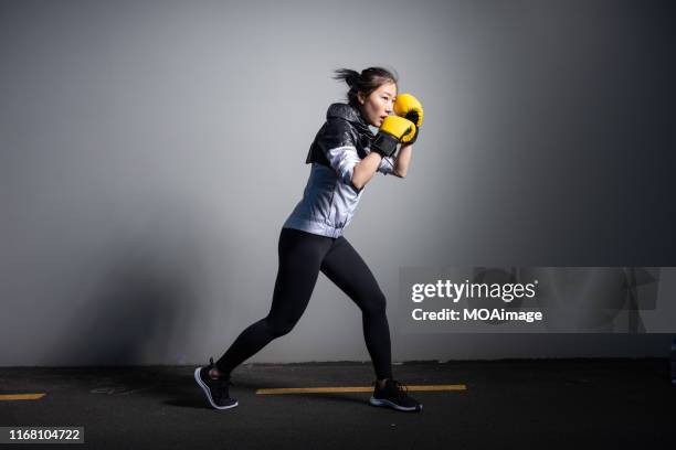 a young asian woman in sportswear is exercising - 女子ボクシング ストックフォトと画像