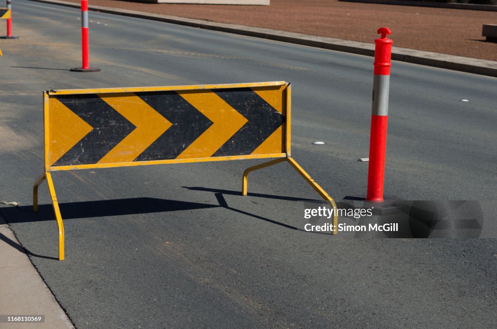 Right traffic arrow/ chevron sign and plastic bollards near roadwork