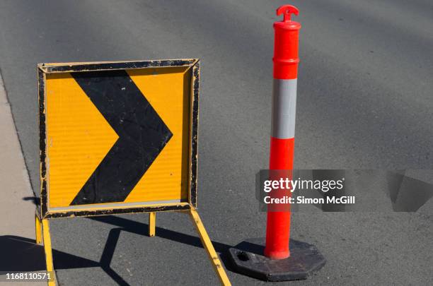 right traffic arrow/ chevron sign and plastic bollards near roadwork - fahrbahn verengung stock-fotos und bilder