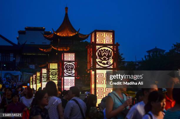 a view of crowded ancient street in the modern city of nanjing china. it shows a glimpse of chinese cultural art and architecture, which is quite rich and a part of japanese / chinese ancient culture expanding over various dynasties including ming dynasty - storefront-for-art-and-architecture stock pictures, royalty-free photos & images