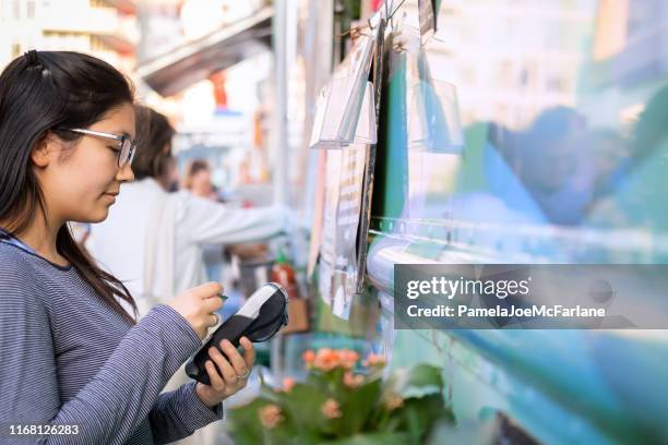 woman making contactless payment on mobile terminal at food truck - food truck payments stock pictures, royalty-free photos & images