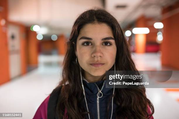 cool young girl listening to music with earphones indoors - determination imagens e fotografias de stock