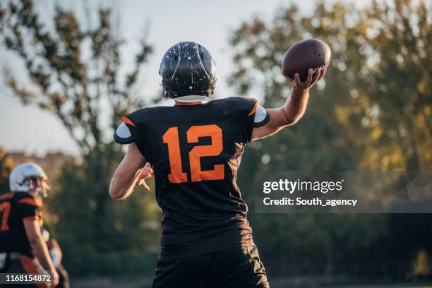 football player throwing a ball - wide receiver athlete stock pictures, royalty-free photos & images