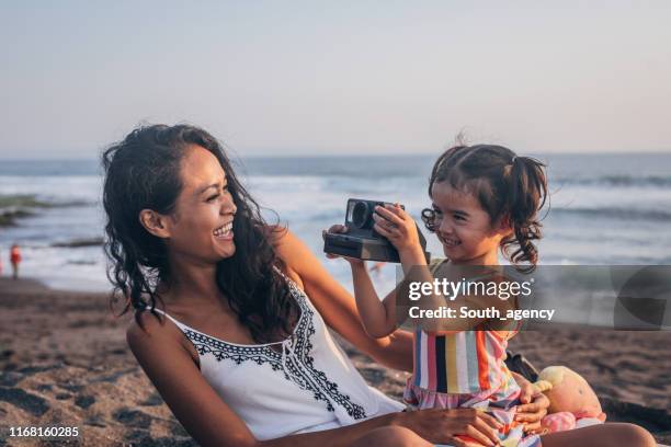 mother and little daughter making memories on the beach - kids fun indonesia stock pictures, royalty-free photos & images