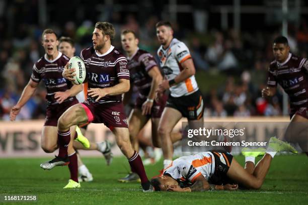 Brendan Elliot of the Sea Eagles makes a break during the round 22 NRL match between the Manly Sea Eagles and the Wests Tigers at Lottoland on August...