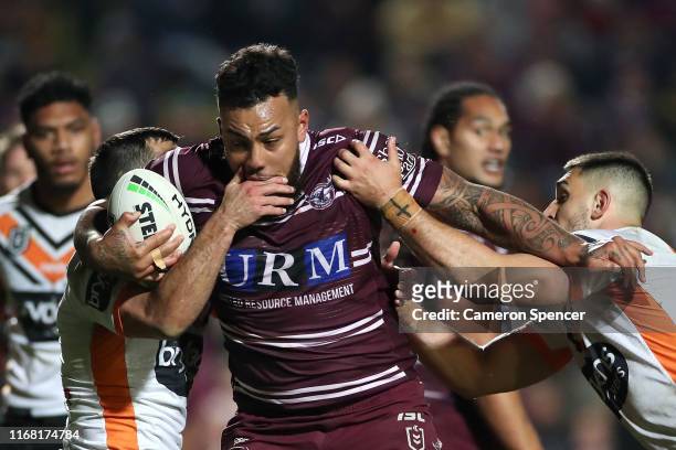 Addin Fonua-Blake of the Sea Eagles is tackled during the round 22 NRL match between the Manly Sea Eagles and the Wests Tigers at Lottoland on August...