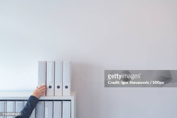 hand reaching for document ring binder on office shelf - woman reaching hands towards camera stock pictures, royalty-free photos & images