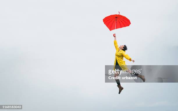 暖かい気候に飛び立つ - raincoat ストックフォトと画像