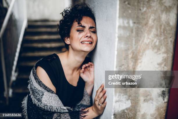 young woman crying on the stairs - woman crying stock pictures, royalty-free photos & images