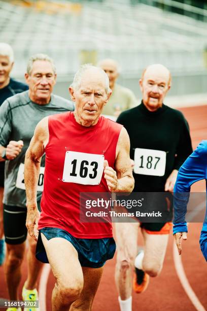 Senior male track athletes running distance race on track