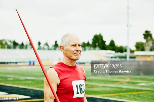 Portrait of senior male track and field athlete holding javelin