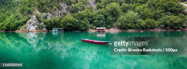 red boat on the river - branko radulovic stock-fotos und bilder