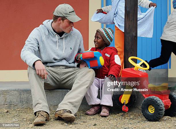Prince Harry sticks out his tongue as he jokes with a child during a visit to the Lesotho Child Counselling Unit on July 9, 2008 in Maseru, Lesotho....