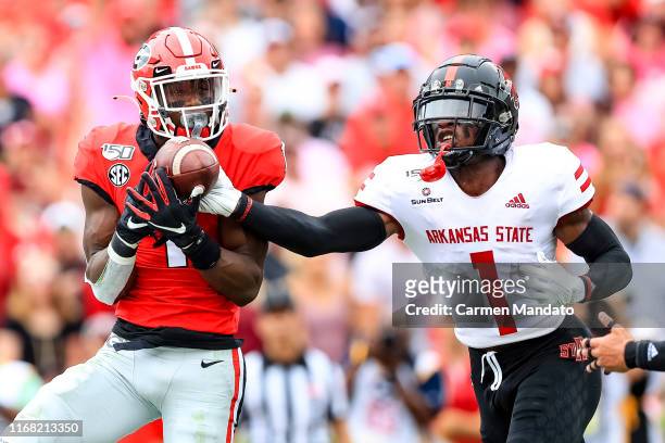 George Pickens of the Georgia Bulldogs reaches for a pass under tight coverage from Jerry Jacobs of the Arkansas State Red Wolves during the first...