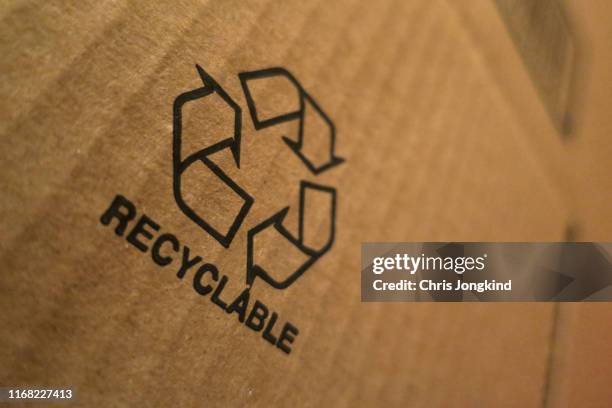 recyclable icon on cardboard box - recycled material stock pictures, royalty-free photos & images