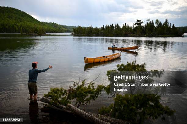 Bob Timmons, left, worked with Aidan"r"n Jones to Retrieve a canoe which floated away from the campsite when Aidan"r"n took the other canoe out...