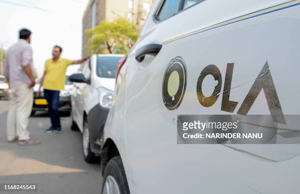 In this photograph taken on September 12 Ola cab drivers talk with each other as they wait for passengers by a roadside in Amritsar. - When India's...