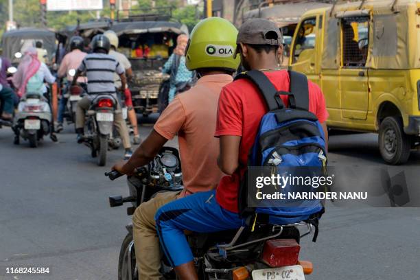 In this photograph taken on September 12 an Ola motorcyclist transports a passenger in Amritsar. - When India's Finance Minister Nirmala Sitharaman...