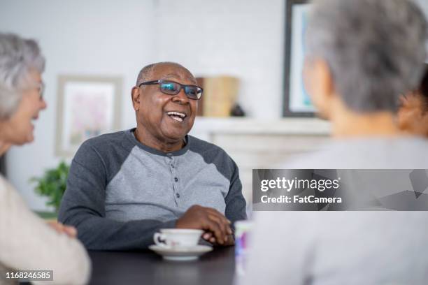 senior man having tea with friends - retirement community stock pictures, royalty-free photos & images