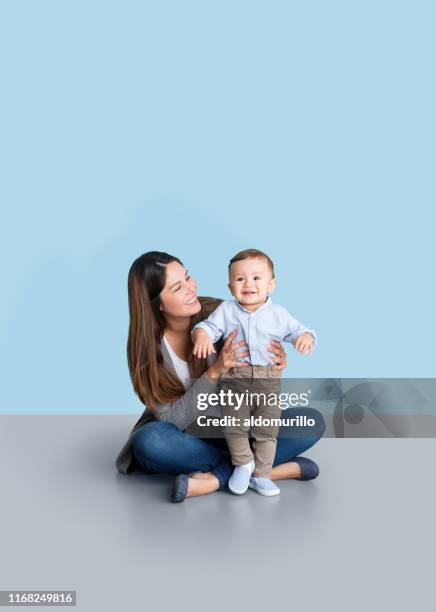 young mother helping baby stand - baby attitude stock pictures, royalty-free photos & images