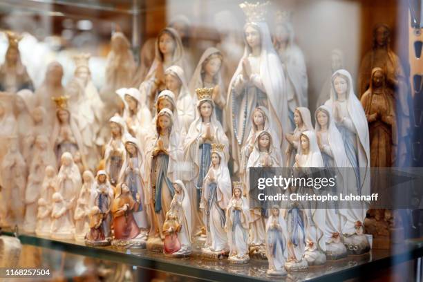 souvenirs representing the virgin sold in shops in lourdes (france) - hautes pyrenees fotografías e imágenes de stock