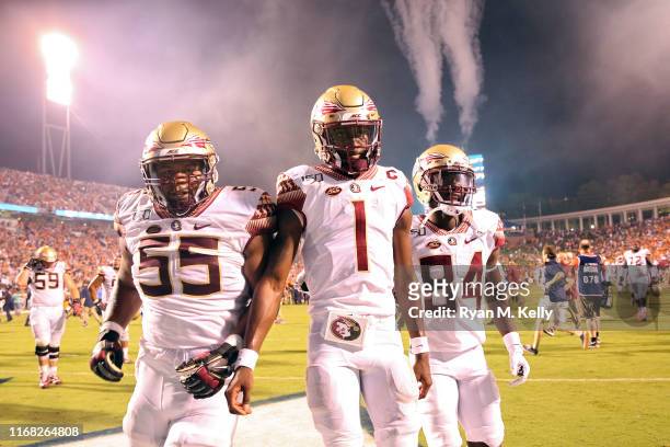 James Blackman of the Florida State Seminoles walks off the field between Dontae Lucas and Adarius Dent after the end of a game against the Virginia...