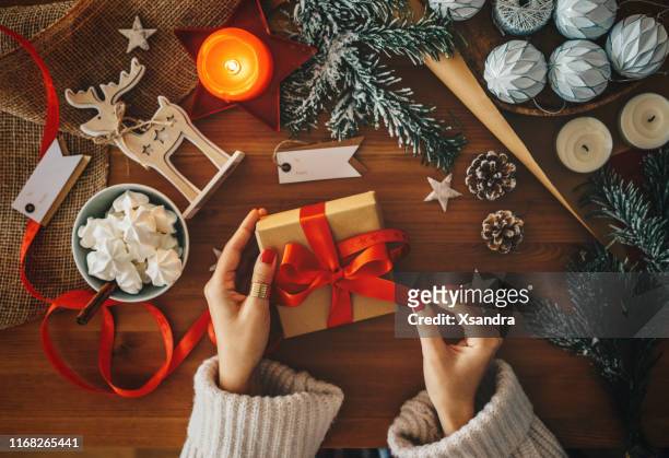 mujer sosteniendo un regalo de navidad - esmalte de uñas rojo fotografías e imágenes de stock