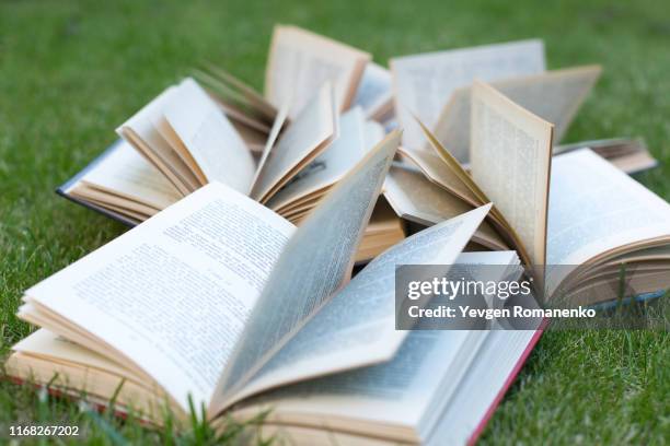 open books lying on a green grass. the concept of learning outdoors - 詩 個照片及圖片檔