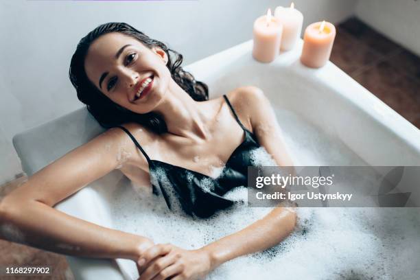 young beautiful woman relaxing in bubble bath - woman bath tub wet hair stock pictures, royalty-free photos & images