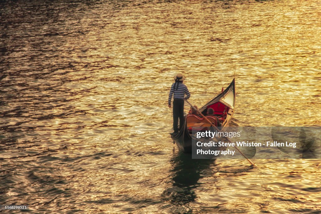 Solitary Gondola Along the Grand Canal in Venice With a Couple Enjoying the Golden Sunlight Hitting the Water