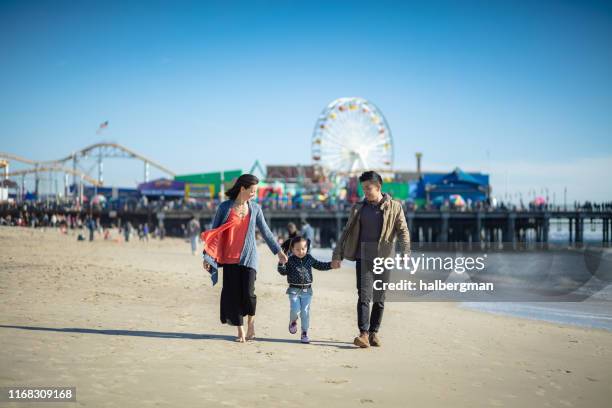 entzückende familie zu fuß auf santa monica beach - santa monica pier stock-fotos und bilder