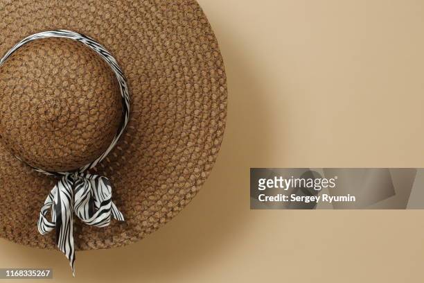 brown sun hat hanging against a beige background - brown hat 個照片及圖片檔