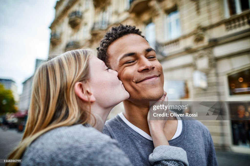 Young woman kissing boyfriend in the city