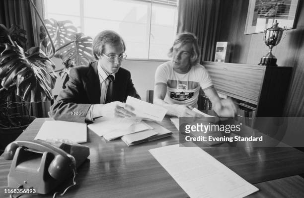 British racing driver James Hunt sorting documents in an office, UK, 20th July 1976.