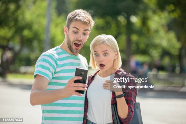 pareja viendo algo en las redes sociales - encontro social fotografías e imágenes de stock