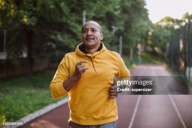 een latijnse man die buitenshuis traint - running man stockfoto's en -beelden