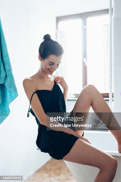 young woman woman feeling her smooth legs in the bathroom at home - animal body part stock pictures, royalty-free photos & images