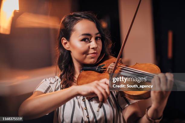 junge geigerin spielt geige - soloist stock-fotos und bilder