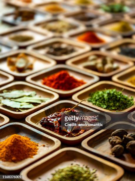 variety of colorful, organic, dried, vibrant indian food spices in wooden trays on an old wood background. - spice stock pictures, royalty-free photos & images