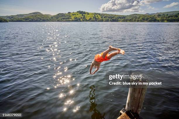 a pre teenage boy diving into coniston water in the lake district, cumbria. uk - 坎布里亞 個照片及圖片檔