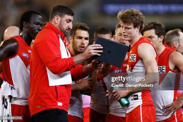 Swans assistant coach Dean Cox uses a tablet to coach players during the round 22 AFL match between the Melbourne Demons and the Sydney Swans at...