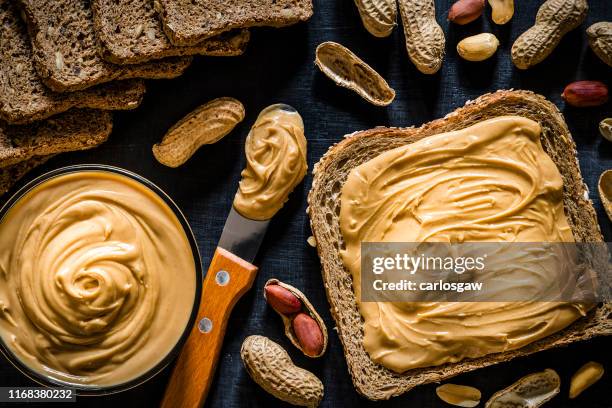peanut butter scattered on a slice of bread - spread imagens e fotografias de stock