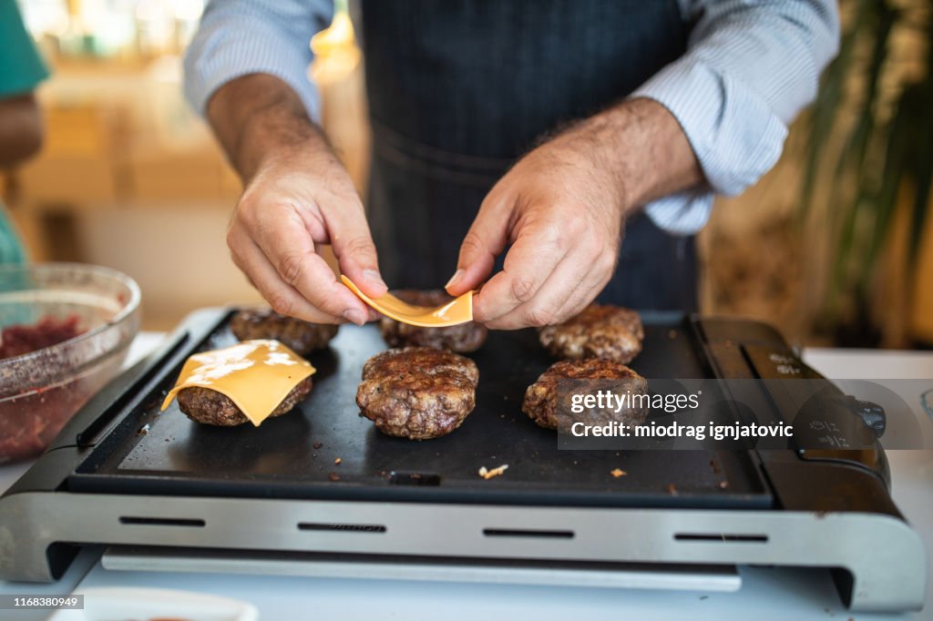 Kaas op hamburgers zetten