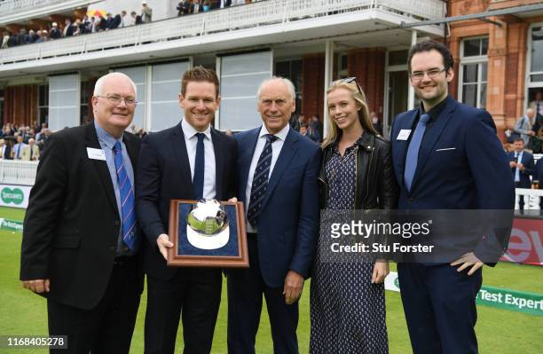 England One Day captain Eoin Morgan receives a solid silver cap from ECB Chairman Colin Graves during Day three of the 2nd Ashes Test Match between...