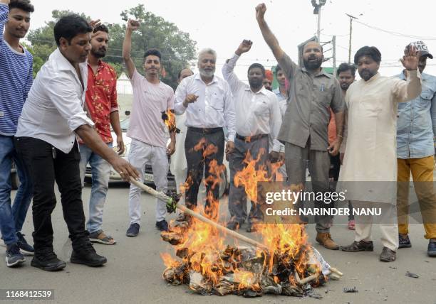 Members of Akhil Bharatiya Sangharsh Dal political party shout slogans as they burn an effigy of Indian Prime Minister Narendra Modi during a protest...